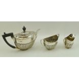 GEORGE EDWARD & SONS AN EDWARDIAN SILVER THREE-PIECE BACHELOR TEA SET, comprising fluted teapot,