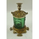 A LATE VICTORIAN ELECTRO-PLATE MOUNTED GREEN GLASS INKWELL with taper stick on a decorative cover,
