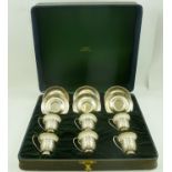 A CASED SET OF SIX "LENOX" PORCELAIN COFFEE CUPS IN STERLING SILVER DECORATIVE HOLDERS with saucers,