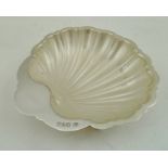 A SILVER BUTTER DISH of scallop shell form, fitted glass liner, Chester 1912, 80g.