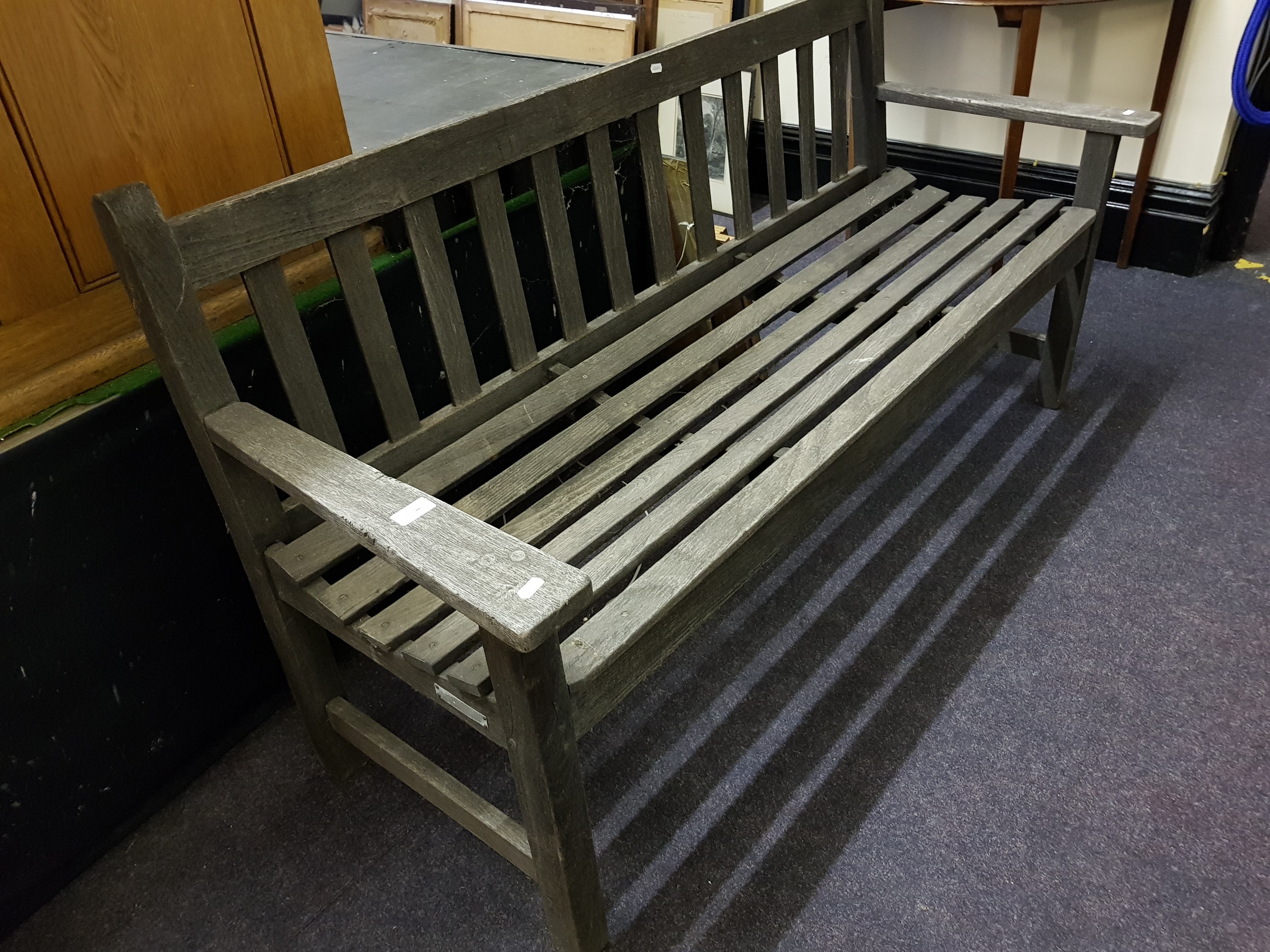 A stained wood lath back garden bench.