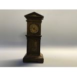 A miniature mantel clock in temple design case. Height 27cm.