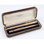 A 9ct yellow gold Swan by Mabie Todd & Co. fountain pen and propelling pencil, engine turned