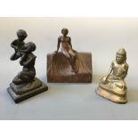 A Buddha statue with mother and child sculpture and wooden sculpture depicting seated female.