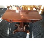 A Victorian mahogany folding top table on scroll feet.