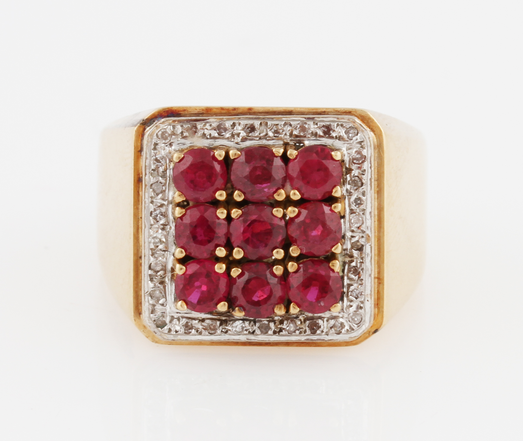 A ruby and diamond ring, set with nine round cut rubies (possibly synthetic), surrounded by a border