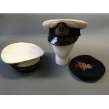 A white navy captains hat, with H.M.S. Dryad sailors hat and blue beret with tassel.
