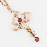 An Edwardian red paste pendant, of lobed open metalwork design with dropper, stamped 9ct, on a