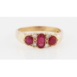 A 9ct yellow gold ruby and diamond ring, set with three principal graduated oval cut rubies,