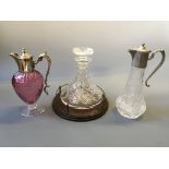 A ships decanter and two silver topped port decanters.