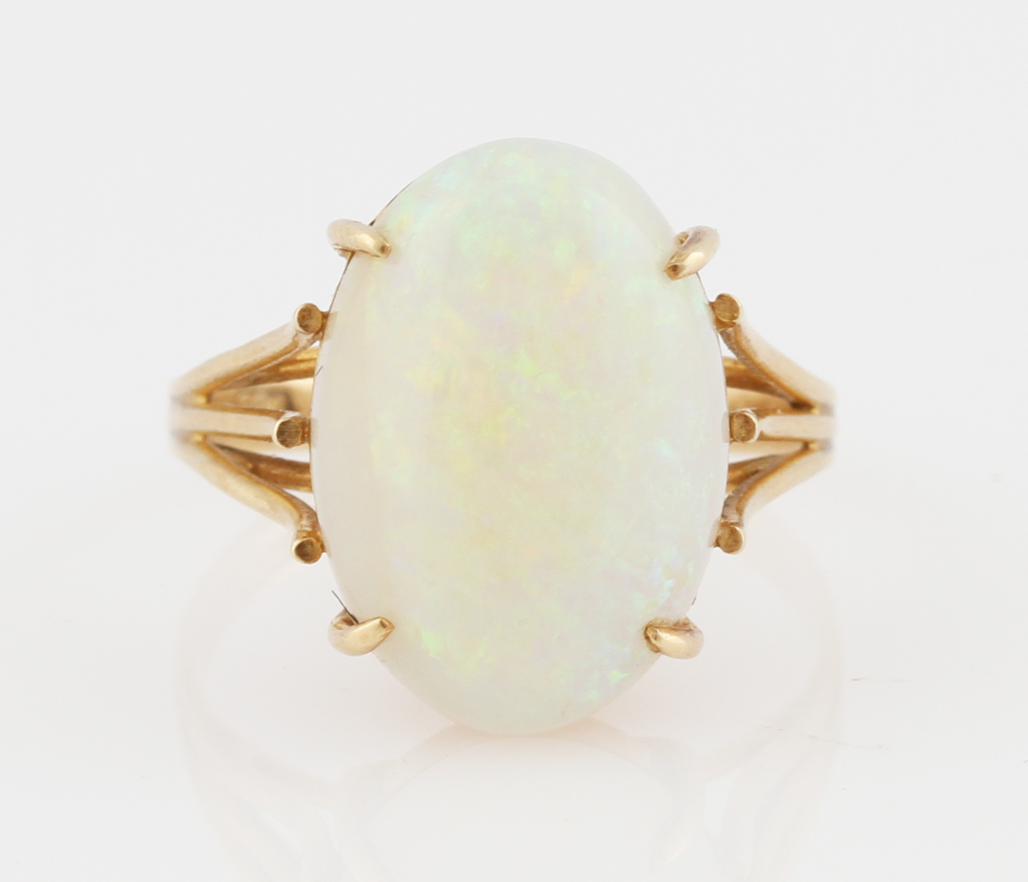 An opal ring, set with an oval opal cabochon, measuring approx. 16x11mm, to a split shoulder