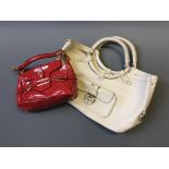 Two Jimmy Choo handbags, one white leather, one small glossy red.