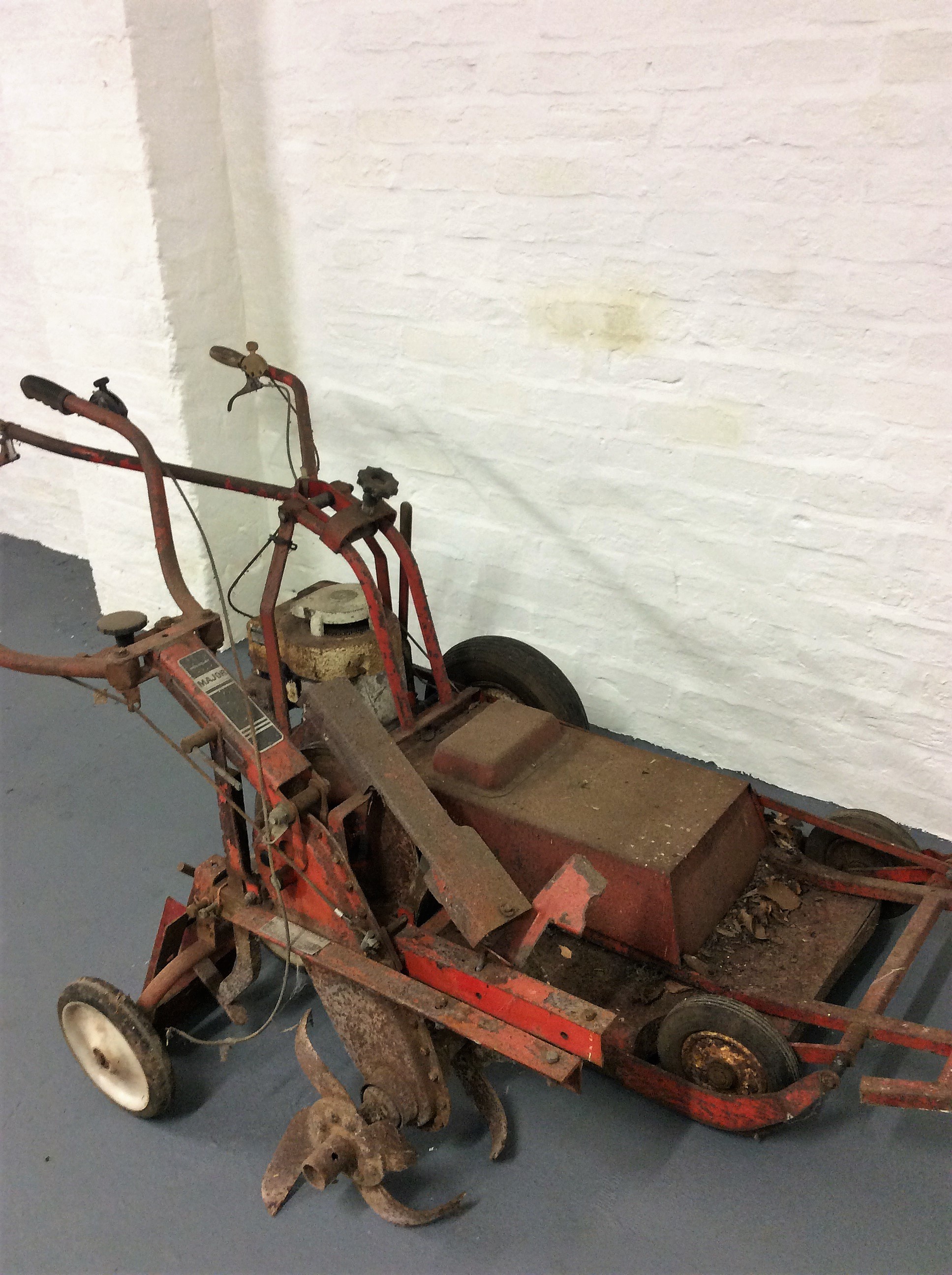 A Wolseley major cultivator together with a Briggs & Stratton lawnmower.