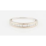 An 18ct white gold diamond half eternity ring, channel set with eighteen baguette cut diamonds,