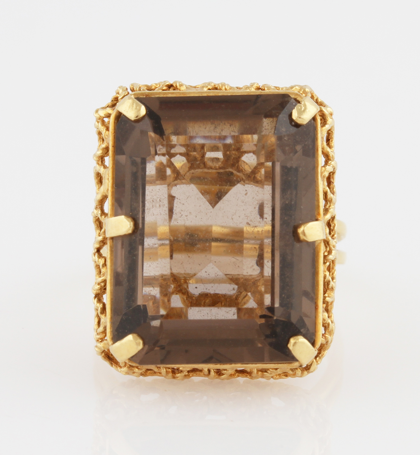 A smoky quartz dress ring, set with a rectangular cut smoky quartz, with open metalwork gallery,