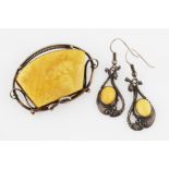 A suite of butterscotch amber jewellery, comprising a brooch and a pair of drop earrings with