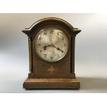 An oak cased mantel clock with brass columns.