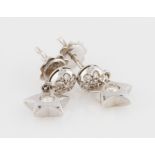 A pair of 18ct diamond stud earrings, the circular diamond set stud suspending star shape set with