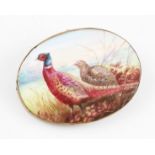 A painted porcelain brooch, depicting pheasant, signed reverse A. H. Wright, possibly for Minton,