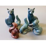 Two Poole pottery cats, otter with fish, two sea lions, and a squirrel.