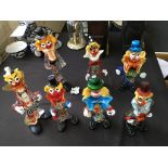 Seven various coloured glass clowns.