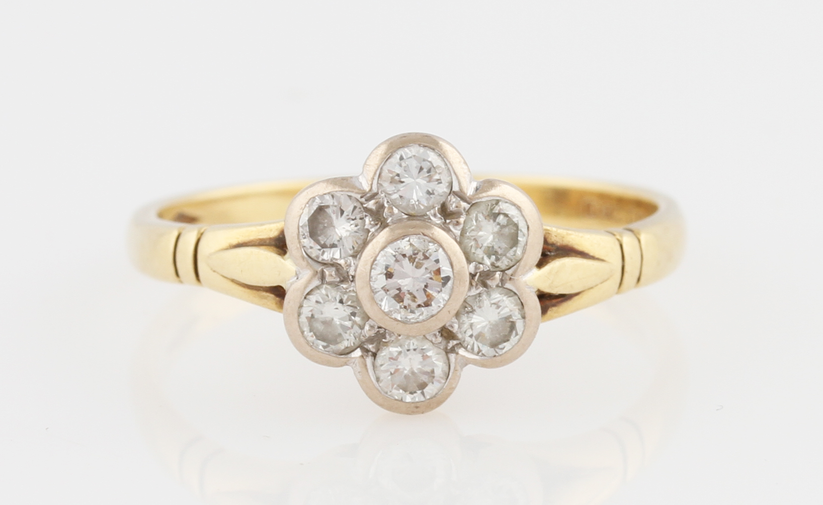 An 18ct yellow gold diamond flower cluster ring, set with a central round brilliant cut diamond,