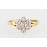 An 18ct yellow gold diamond flower cluster ring, set with a central round brilliant cut diamond,