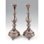 A pair of 19th Century silver Russian candlesticks, the knopped baluster form of repousse design, on