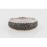 A colourless and black diamond ring, half band set with three central rows of round brilliant cut