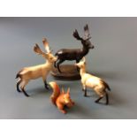 A collection of Beswick figurines to include three stags and a squirrel.