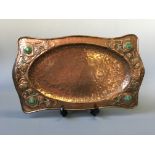 A hand beaten arts and craft style copper tray with leaf design.