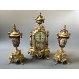 A French style brass and ceramic clock with two garnishes, decorated with pastoral couple scenes.