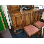 An oak sideboard and four chairs with carved decoration.