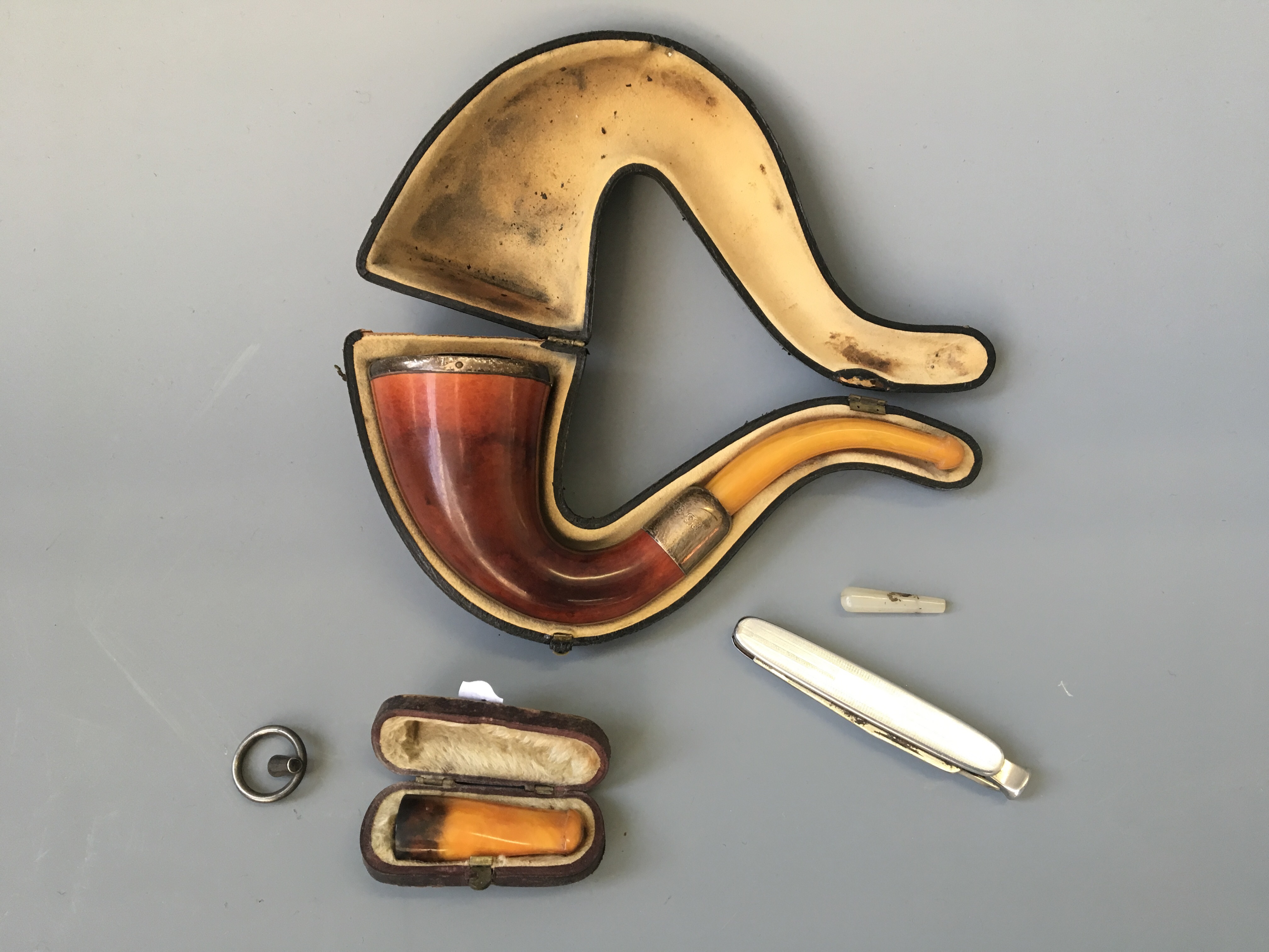 A smoking pipe in a case with various accessories.