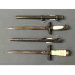 Two German style daggers with metal decorative scabbards.