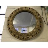 A circular mirror with decorative pattern framing.