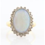 An 18ct yellow gold opal and diamond cluster ring, set with a central oval opal cabochon,