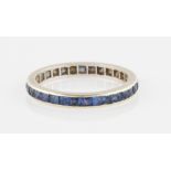 A sapphire full eternity ring, set with square cut sapphires, in unmarked white metal, ring size Q.