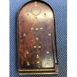 A stained wood bagatelle game with metal balls.