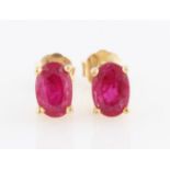 A pair of ruby stud earrings, each set with an oval cut ruby, measuring approx. 6x4mm, stamped 375.