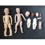 A box of various doll parts including bisque heads and limbs, with two dolls, one bisque marked KR