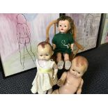 Three various dolls and a child's elbow chair.