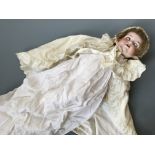 An Armand Marseille Germany 990 A 4 M doll with bisque head in christening dress.