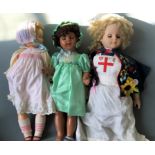 Three dolls, one Uneeda Doll Co. 8176 ME nurse doll, one marked F.P. and one in green dress.