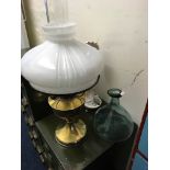 A brass oil lamp together with an onion shaped glass decanter sealed with bearded man and resin