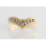 An 18ct yellow gold nine stone wishbone ring, channel set with nine graduated round brilliant cut