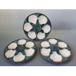 A set of four Majolica oyster plates, green with brown edge by Longchamp.