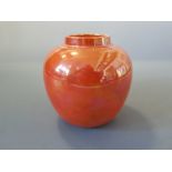 An orange coloured ginger jar, lid missing marks to base Ruskin England 1921.