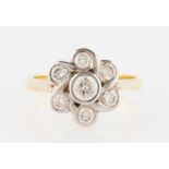 An 18ct yellow gold diamond flower design ring, set with seven round brilliant cut diamonds, the