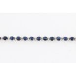 A contemporary sapphire and diamond line bracelet, set with 27 sapphires, each measuring approx.